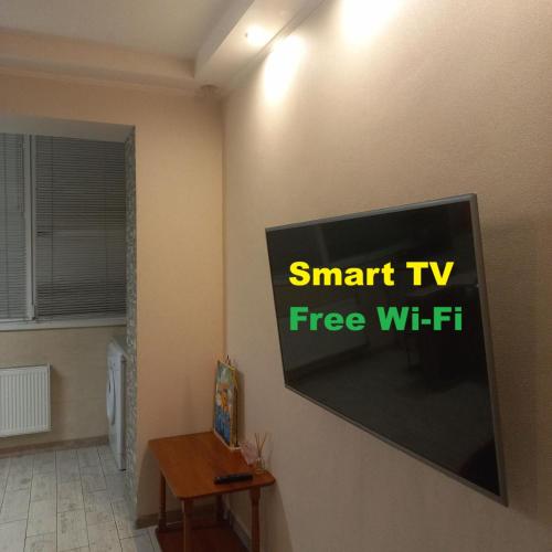 a flat screen tv hanging on a wall in a room at StudioCaffe - апартаменти з самостійним заселенням біля метро Академіка Павлова in Kharkiv