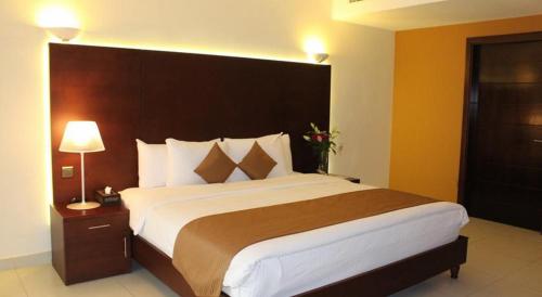 a bedroom with a large bed with a large headboard at Sohar Beach Hotel in Sohar