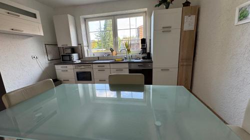 Una cocina con una mesa de cristal en una cocina. en Ferienwohnung 2 mit Garten, en Hannover