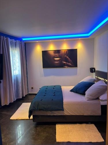 Schlafzimmer mit einem Bett mit blauem Licht in der Unterkunft La parenthèse dorée in Les-Pennes-Mirabeau