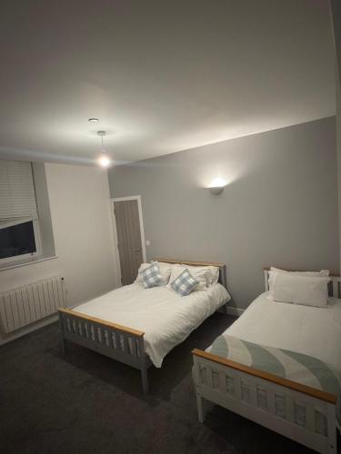 una habitación con dos camas y una ventana en Spacious 4BR Apartment 7 Beds Near Station, en Newport