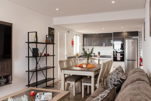 a living room with a couch and a table and a kitchen at Casa Piquita in Estreito da Calheta