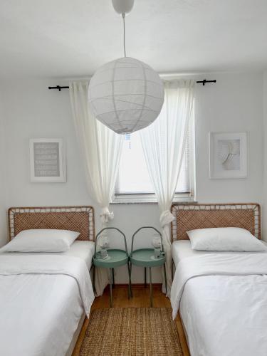 a room with two beds and a chandelier at Lúmina Vir in Vir