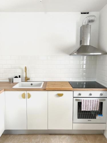 a kitchen with white cabinets and a sink at Lúmina Vir in Vir