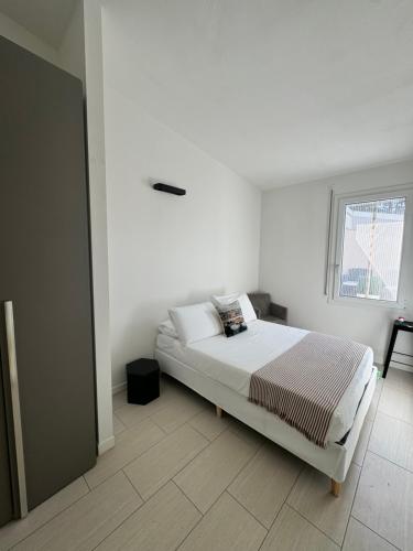 a white bedroom with a bed and a window at Celeste's House in Florence
