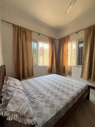 a bedroom with a large bed in front of windows at Private Villa in Bagamoyo in Bagamoyo