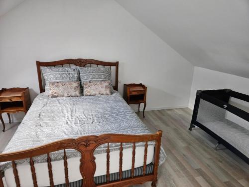 una camera da letto con un grande letto in legno con cuscini di Casă mică și șarmantă la țară a Plonévez-du-Faou