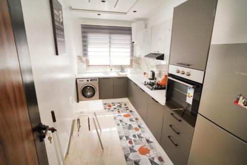 a small kitchen with a stove and a sink at 5 min drive from Train Station with Parking, Air Conditioning & IPTV -Ideal for CAN 2025 in Kenitra