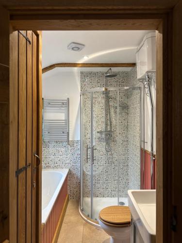 ein Badezimmer mit Badewanne, Toilette und Dusche in der Unterkunft Curiosity Cottage in Wendover