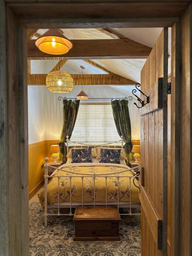 ein Schlafzimmer mit einem Bett und einem Fenster in der Unterkunft Curiosity Cottage in Wendover