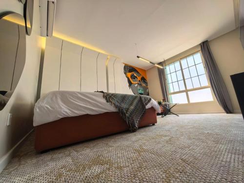 a bedroom with a bed and a large window at مهند هوم 24 in Al Khobar
