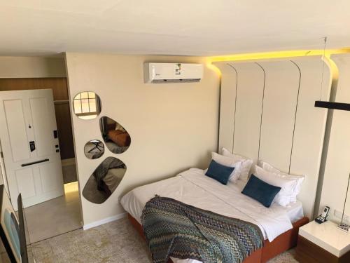 a small bedroom with a bed with blue pillows at مهند هوم 24 in Al Khobar
