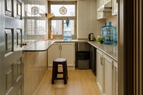 a kitchen with a stool in the middle of a room at Classic Capsule Holiday Homes in Dubai