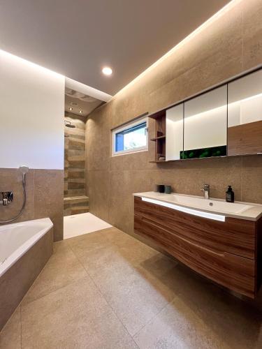 a bathroom with a tub and a sink and a bath tubermottermott at Lodge am Wasser in Yspertal