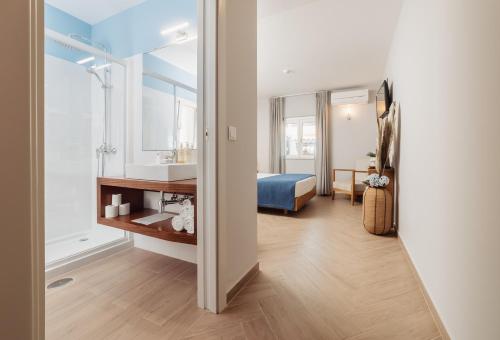 a bedroom with a bed and a bathroom with a mirror at AZUL in Zambujeira do Mar