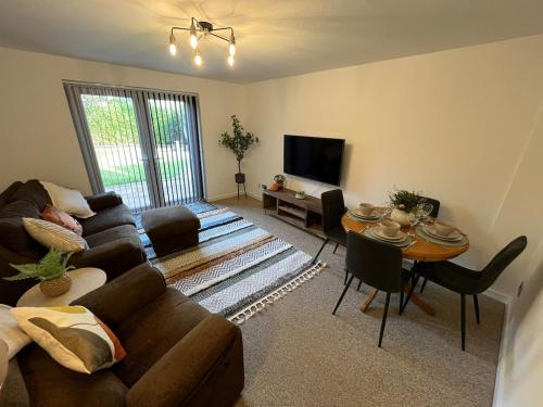 ein Wohnzimmer mit Sofa und Tisch in der Unterkunft Cosy Contractor House with Garden & Parking! in Yeovil