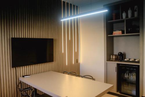 a room with a table and a tv on a wall at Sttudio One in Araxá
