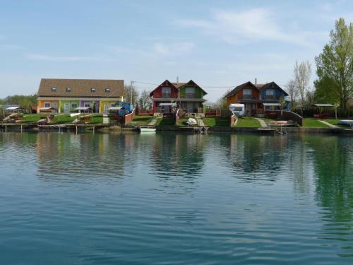 a group of houses next to a body of water at Kis vízparti házikó in Gyékényes