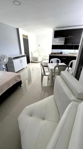 a white living room with a couch and a table at Apartamento Zona Centro in Ibagué