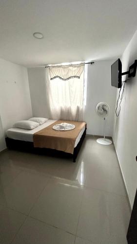 a bedroom with a bed and a window with a fan at Apartamento Zona Centro in Ibagué