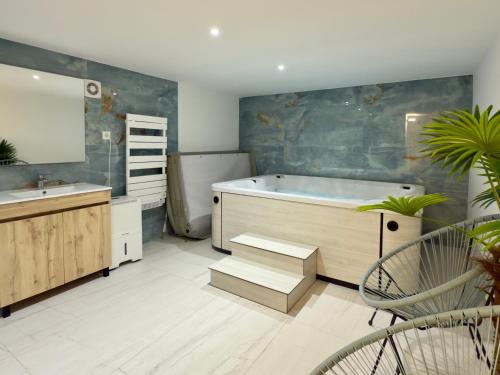 a bathroom with a tub and a sink and a mirror at Appartement spacieux et lumineux - 10 personnes - entre lacs et montagnes in Fillinges