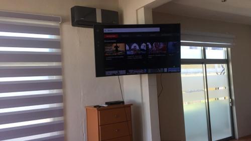 a flat screen tv hanging on a wall in a room at Sea sight appartment in Historic Downtown in Campeche