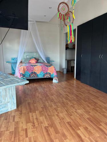 a bedroom with a bed and a wooden floor at Sea sight appartment in Historic Downtown in Campeche