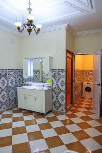 a bathroom with a sink and a checkered floor at najmatriff in Driouch