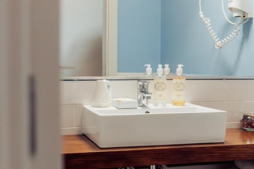 a bathroom with a white sink and a mirror at AZUL in Zambujeira do Mar