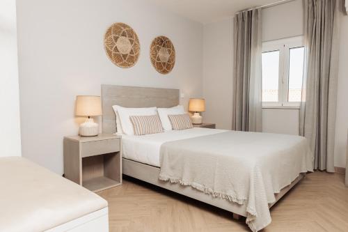 a white bedroom with two beds and two lamps at AZUL in Zambujeira do Mar