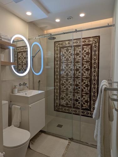 a bathroom with a shower with a toilet and a sink at Mahogany - Rooftop Views - Close to Valletta Ferry in Senglea