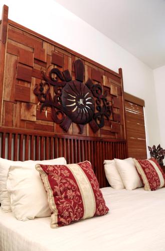 a bedroom with a bed with a large wooden headboard at Turtle Bay Boutique Hotel in Tangalle