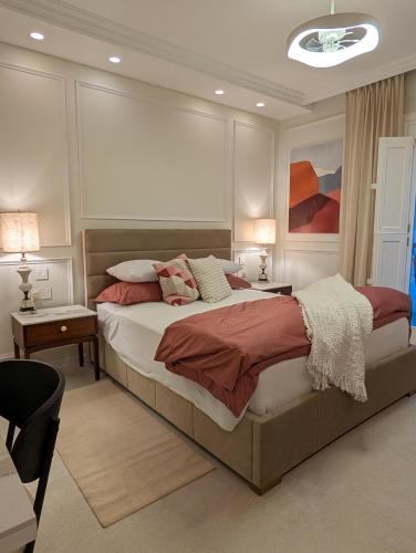 een slaapkamer met een groot bed en 2 tafels en 2 lampen bij Mahogany - Rooftop Views - Close to Valletta Ferry in Senglea