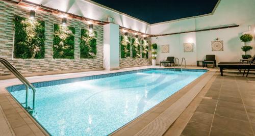 a swimming pool with a table and a piano at Alraya Homes by Betu former Times Inn in Abu Dhabi