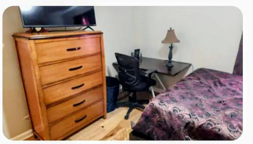 a bedroom with a dresser with a television on top of it at Your Temporary Haven in La Vergne