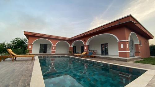 a villa with a swimming pool and a house at L'Eclipse Air-Conditioned Villa with Pool in Mbour