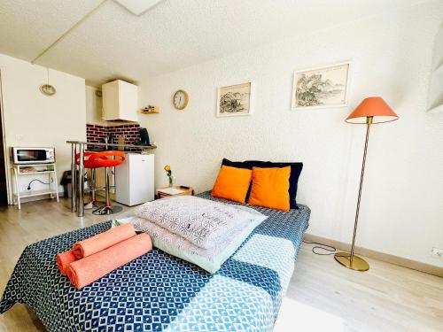 1 dormitorio con 1 cama con almohadas de color naranja en JOLI STUDIO HYPER CENTRE TRES PROCHE VIEUX PORT, en Marsella