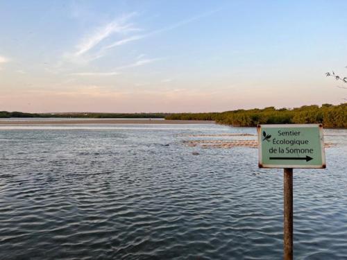 a sign in the middle of a body of water at L'Eclipse Air-Conditioned Villa with Pool in Mbour