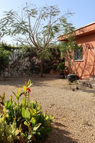 a garden with a grill and some plants and a building at L'Eclipse Air-Conditioned Villa with Pool in Mbour