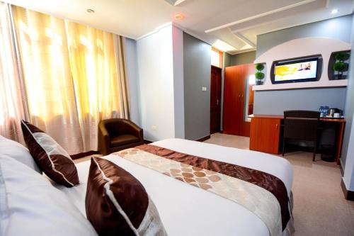 a hotel room with two beds and a television at Green Mountain Hotel in Arusha