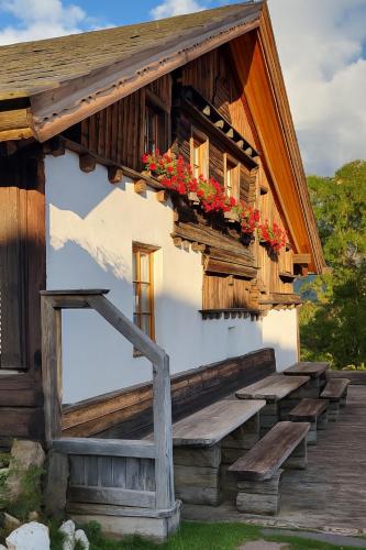 a building with a porch with flowers on it at Himmelbauer Apartments in Söbriach