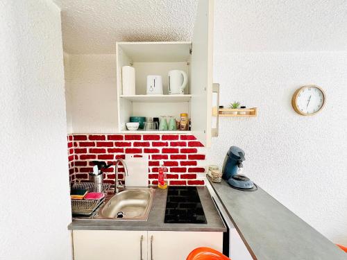 cocina con fregadero y pared de ladrillo rojo en JOLI STUDIO HYPER CENTRE TRES PROCHE VIEUX PORT, en Marsella
