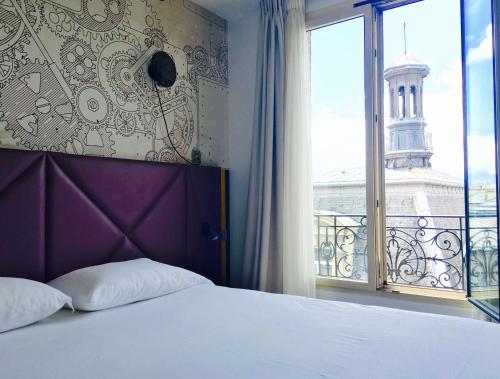 a bedroom with a bed and a large window at ibis Styles Paris Mairie De Clichy in Clichy
