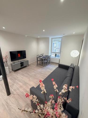 a living room with a couch and a table at Charmant appartement, 2 chambres au bord des quais in Millau