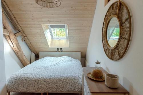 a bedroom with a bed and a mirror on a table at L'arbres aux minutes in Saint-Martin-Sepert