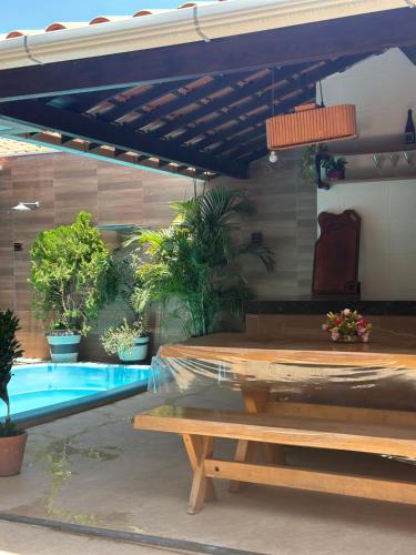 a patio with a table and a swimming pool at Aconhego Dourado I Alugue casa com piscina a 17min da praia in Parnaíba