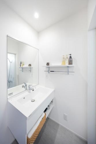 a white bathroom with a sink and a mirror at Villa Uminosora - Vacation STAY 92909v in Karatsu
