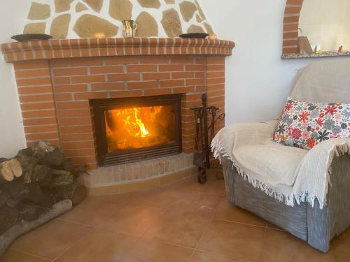 un soggiorno con camino in mattoni e sedia di Las olivas a Alcolea