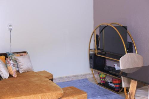 a living room with a couch and a tv at Tasha's suites in Entebbe
