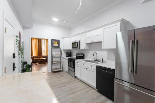 a kitchen with white cabinets and a stainless steel refrigerator at 1734 Comfort Stay, 2 Bedrooms, 2 Bath with Kitchen & Wi-Fi in Washington, D.C.